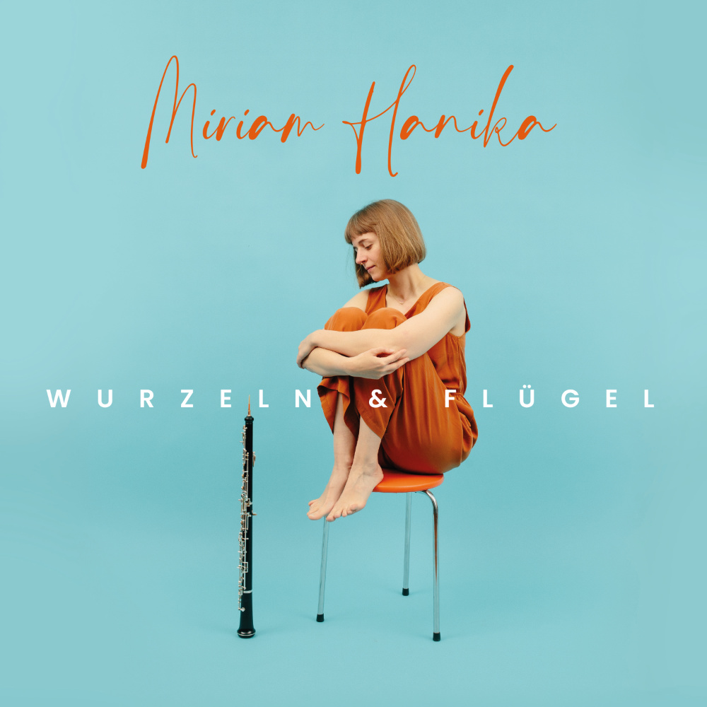 Cover von Miriam Hanikas Album "Wurzeln & Flügel". Miriam Hanika sitzt auf einem orangenen Hocker und betrachtet ihre Oboe vor himmelblauem Hintergrund.